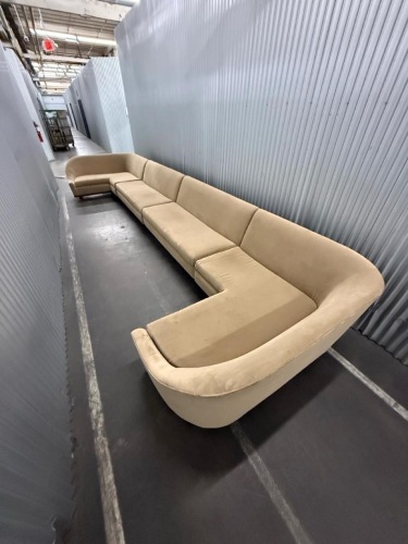 large curved sectional sofa upholstered in beige fabric