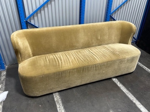 curved upholstered sofa with a gold/mustard velvet fabric