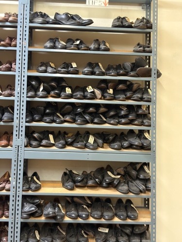 Collection of assorted Men's civilian footwear, on 16 sections of shelving